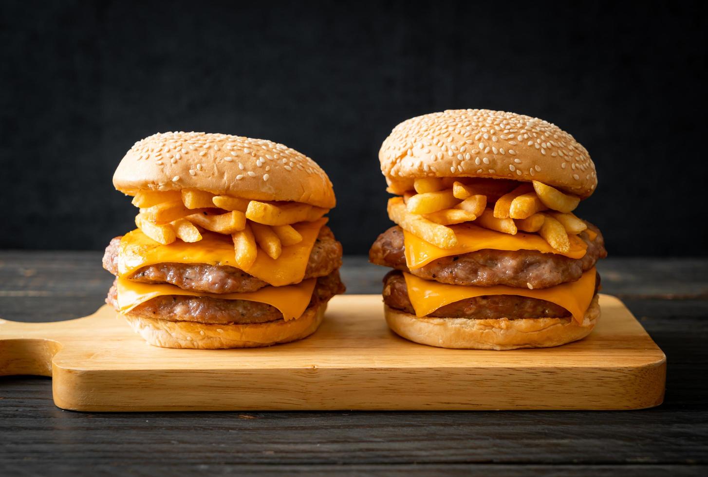 Schweinefleisch-Hamburger oder Schweinefleisch-Burger mit Käse und Pommes frites foto