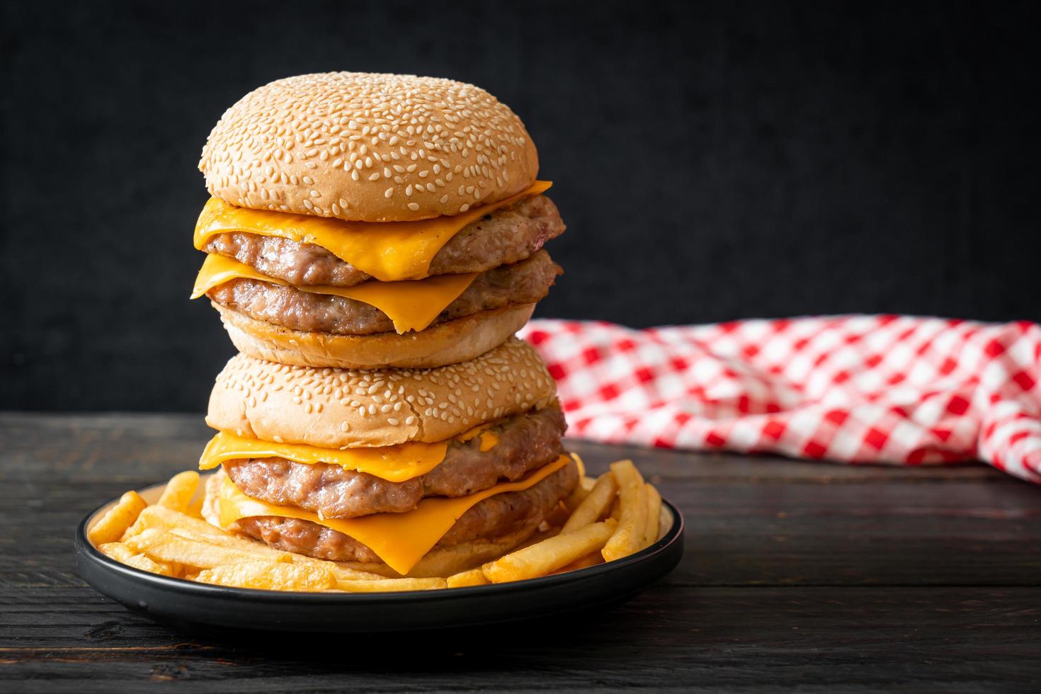 Schweinefleisch-Hamburger oder Schweinefleisch-Burger mit Käse und Pommes frites foto