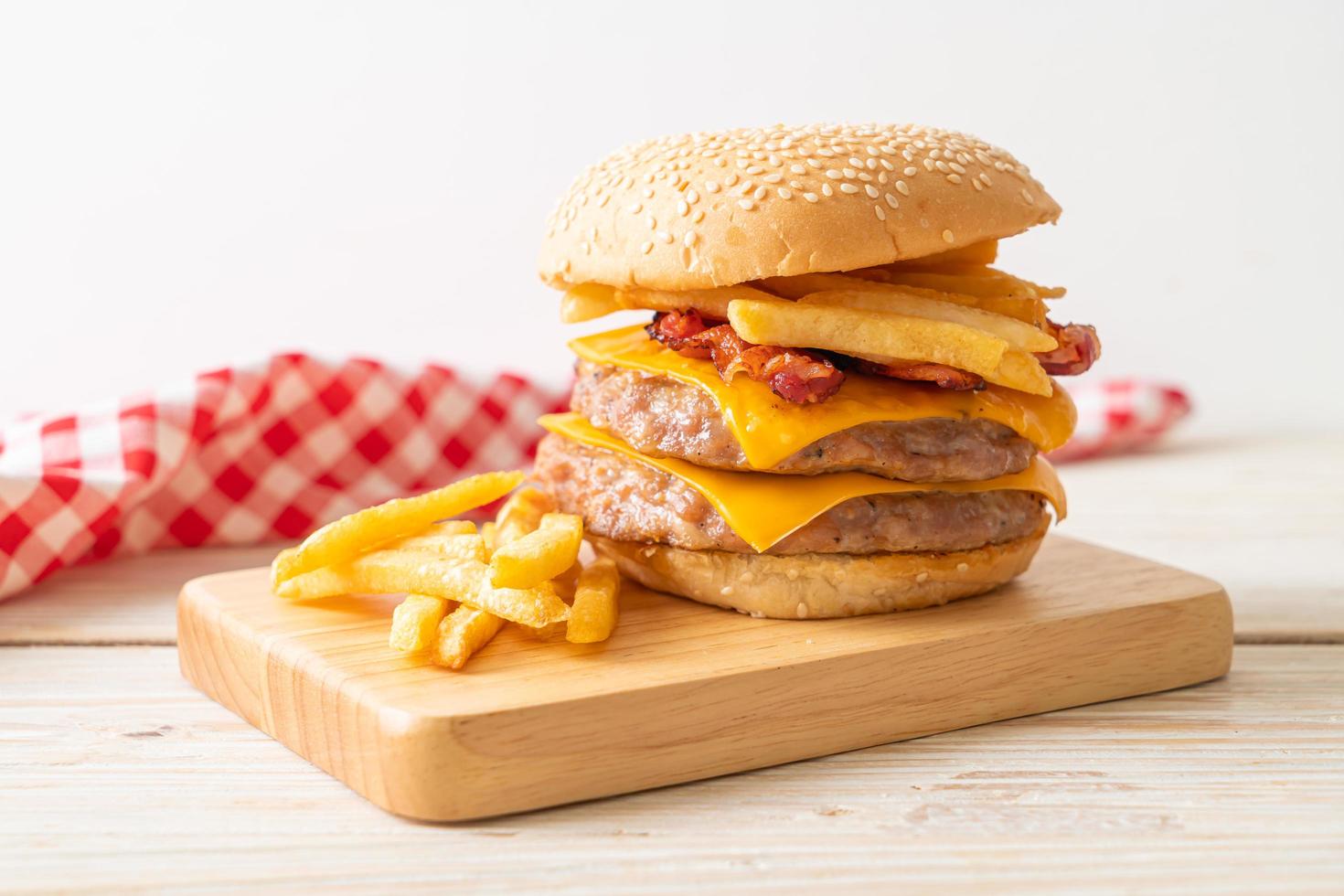 Schweinefleisch-Hamburger oder Schweinefleisch-Burger mit Käse, Speck und Pommes frites foto