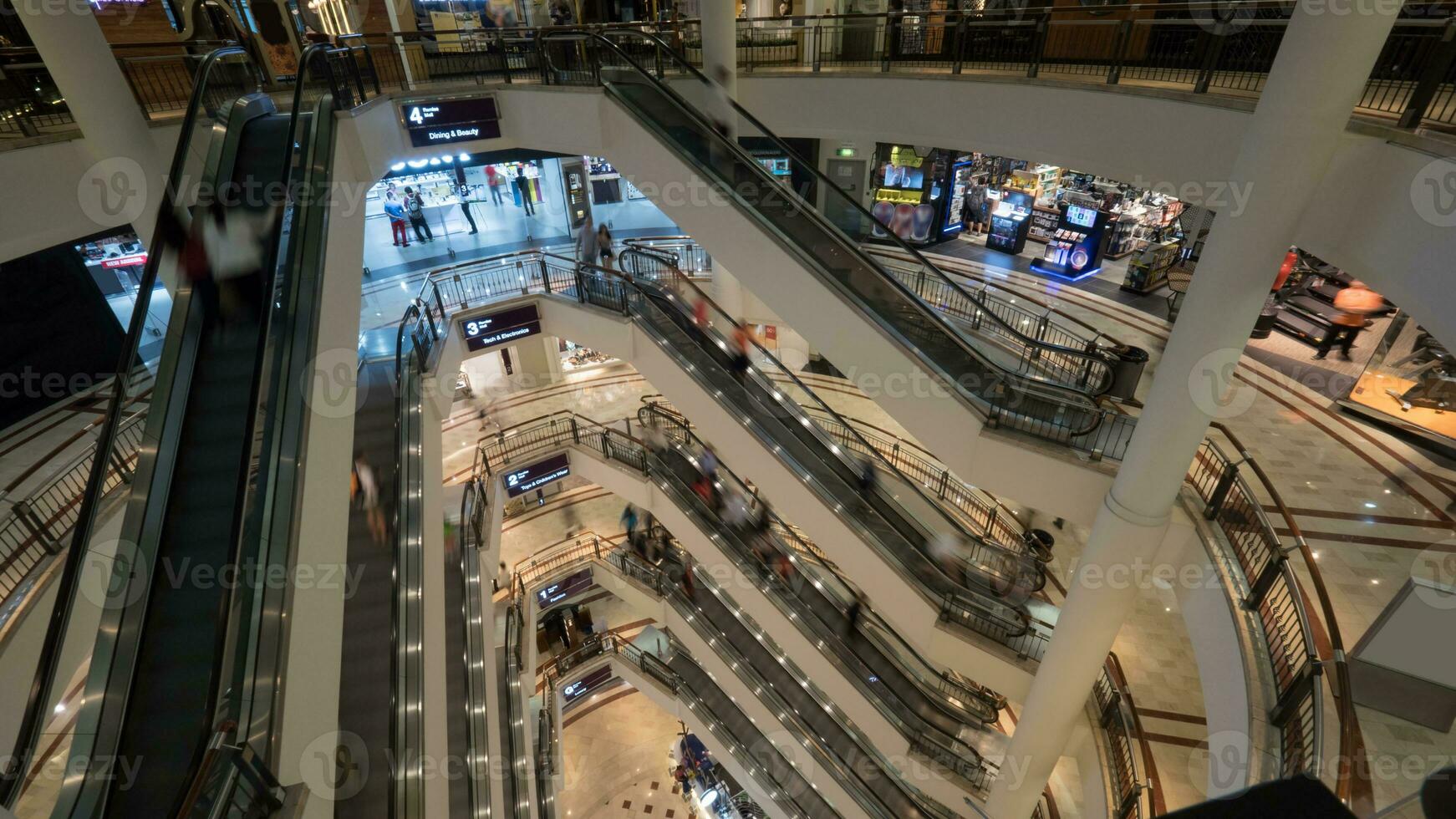 Menschen auf Rolltreppen im mehrstöckig Einkaufen Einkaufszentrum foto
