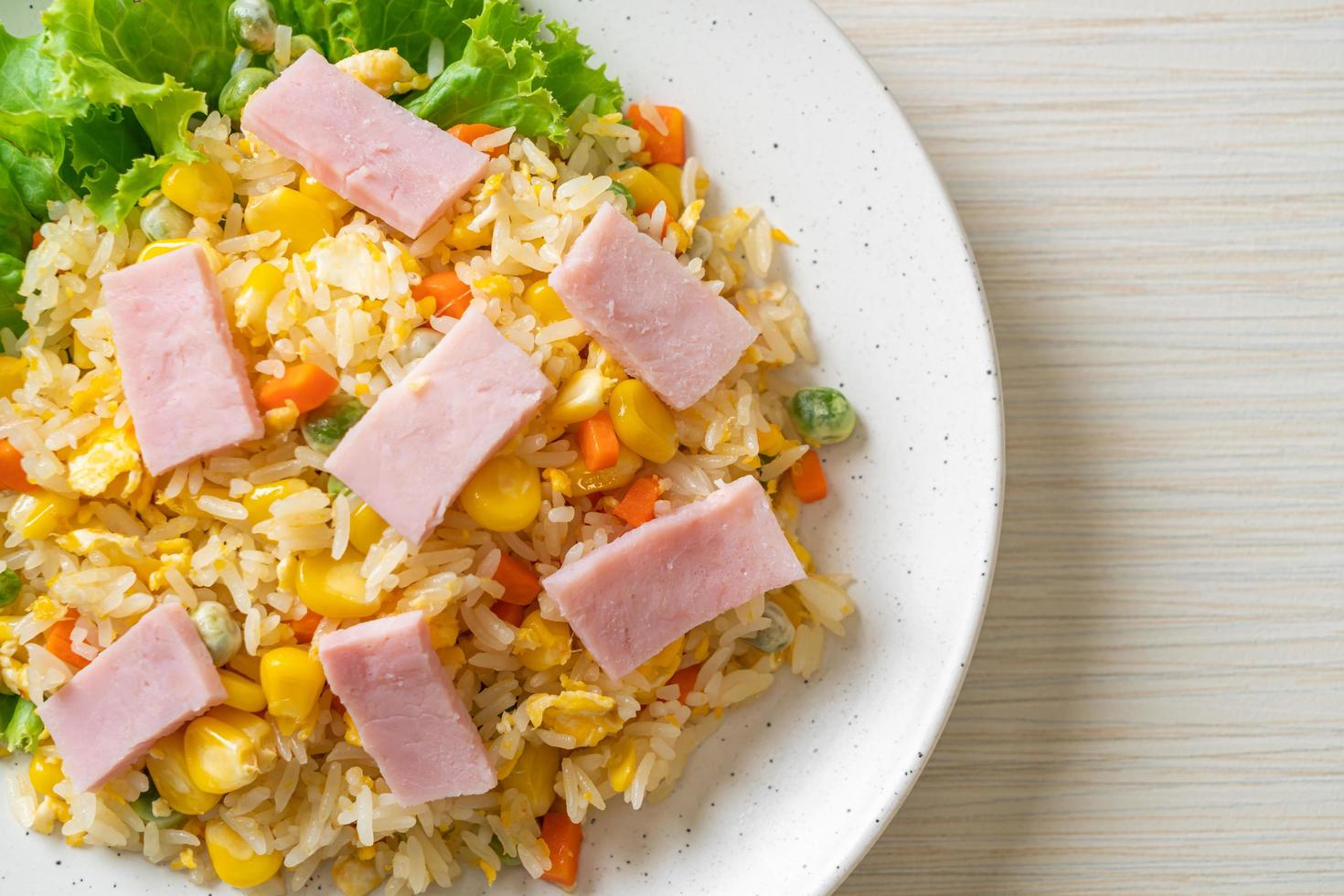 hausgemachter gebratener Reis mit Schinken und gemischtem Karottengemüse und grünen Erbsen foto
