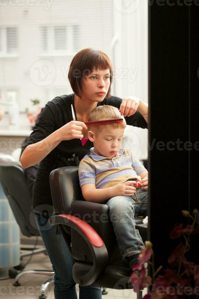 wenig Junge bekommen ein Haarschnitt von Friseur foto