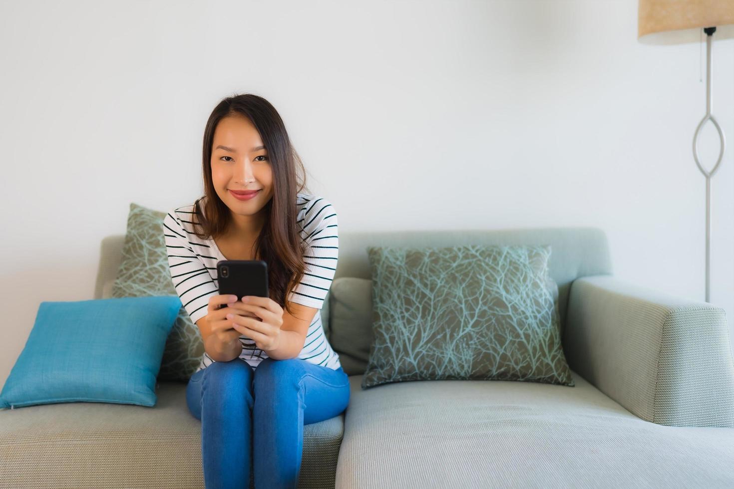 Porträt schöne junge asiatische Frau, die Handy benutzt oder spricht foto