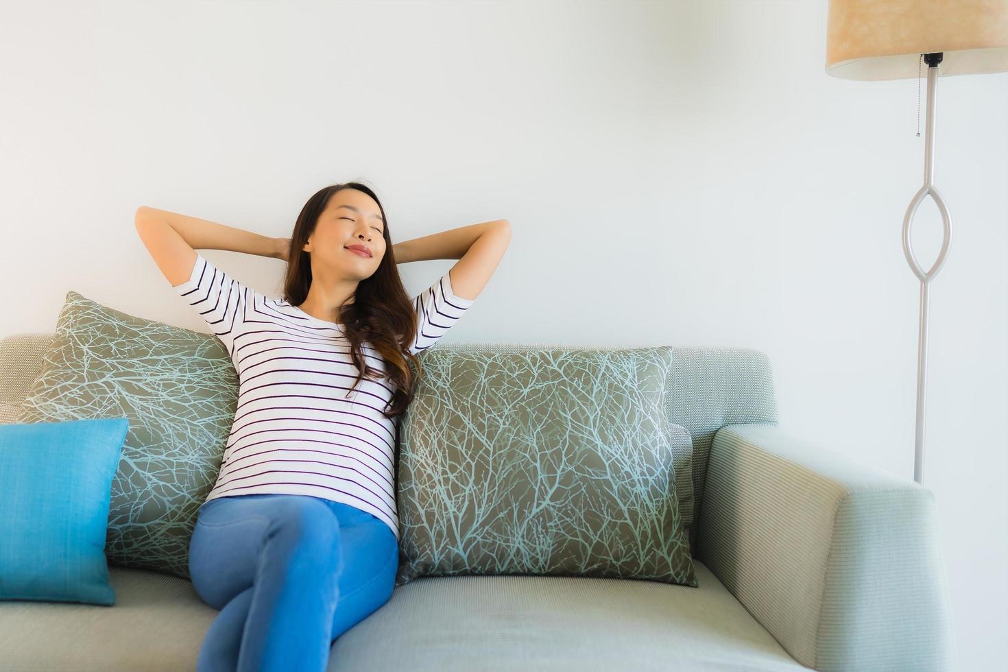 Porträt schöne junge asiatische Frau Lächeln glücklich auf dem Sofa foto