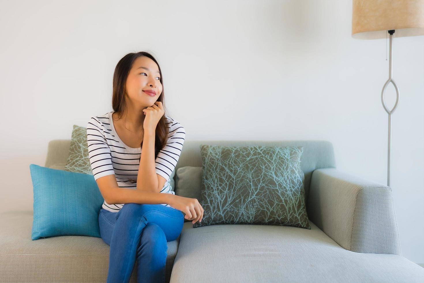 Porträt schöne junge asiatische Frau Lächeln glücklich auf dem Sofa foto