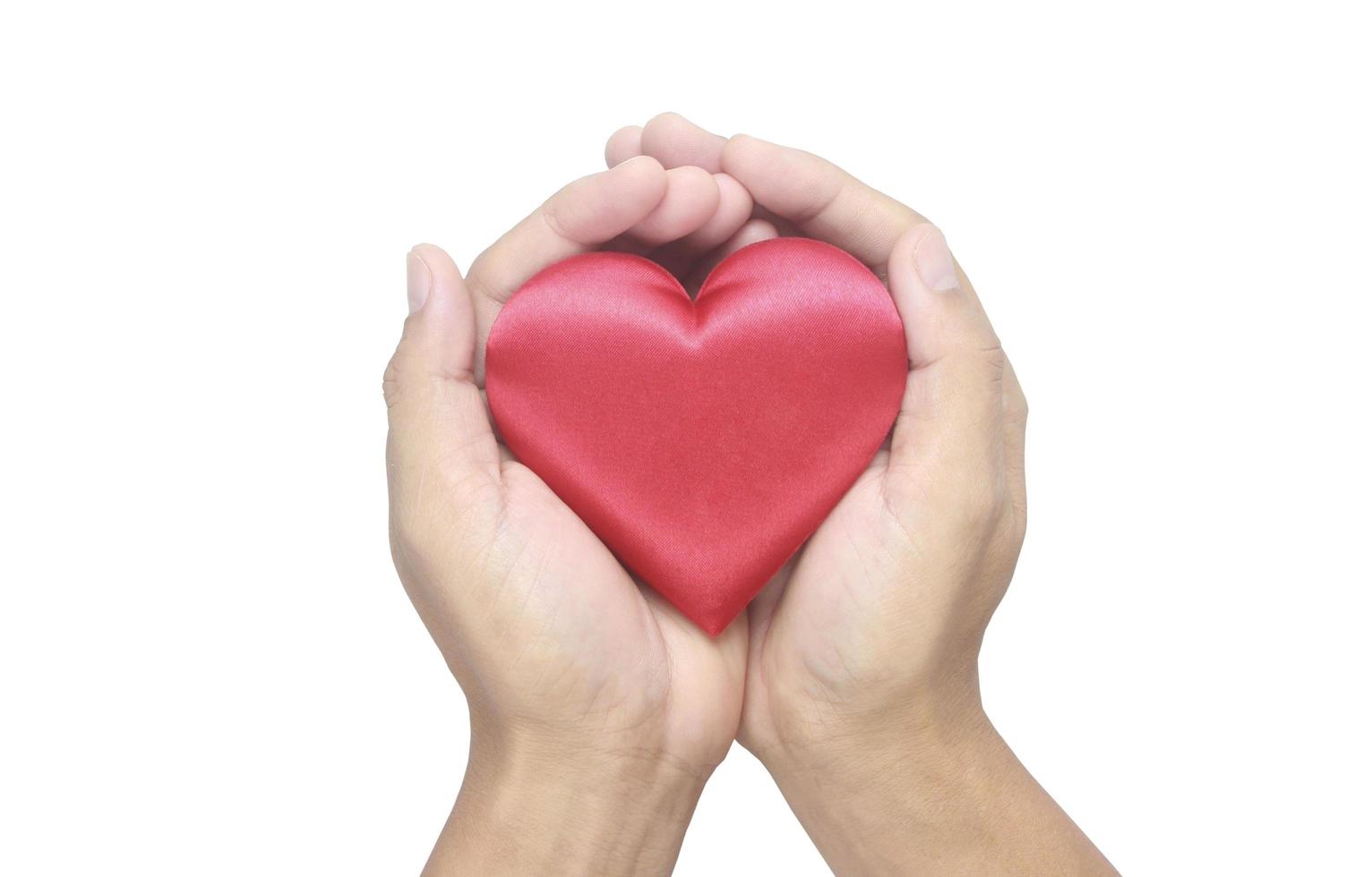 Hände, die rotes Herz halten. Spendenkonzepte für die Herzgesundheit foto