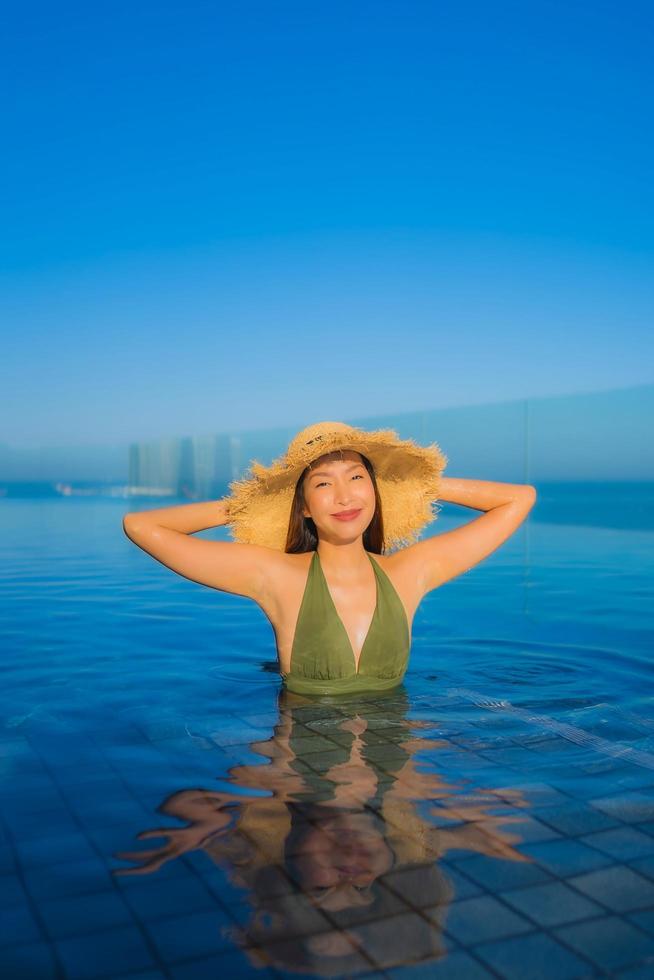 Schöne junge asiatische Frauen glückliches Lächeln entspannen sich im Außenpool im Hotelresort für Reisen in den Ferien? foto