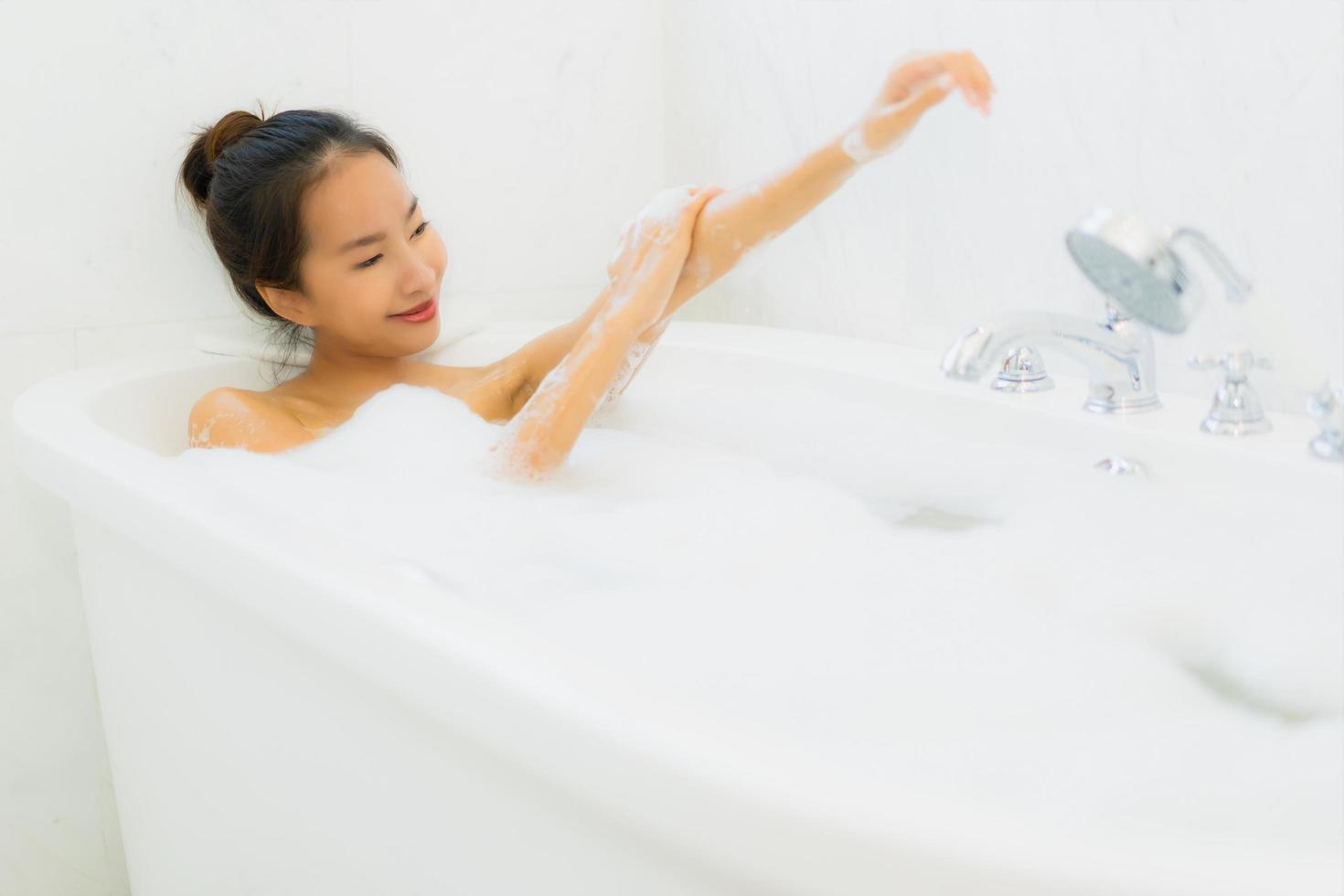 Porträt schöne junge asiatische Frau nimmt eine Badewanne im Badezimmer foto