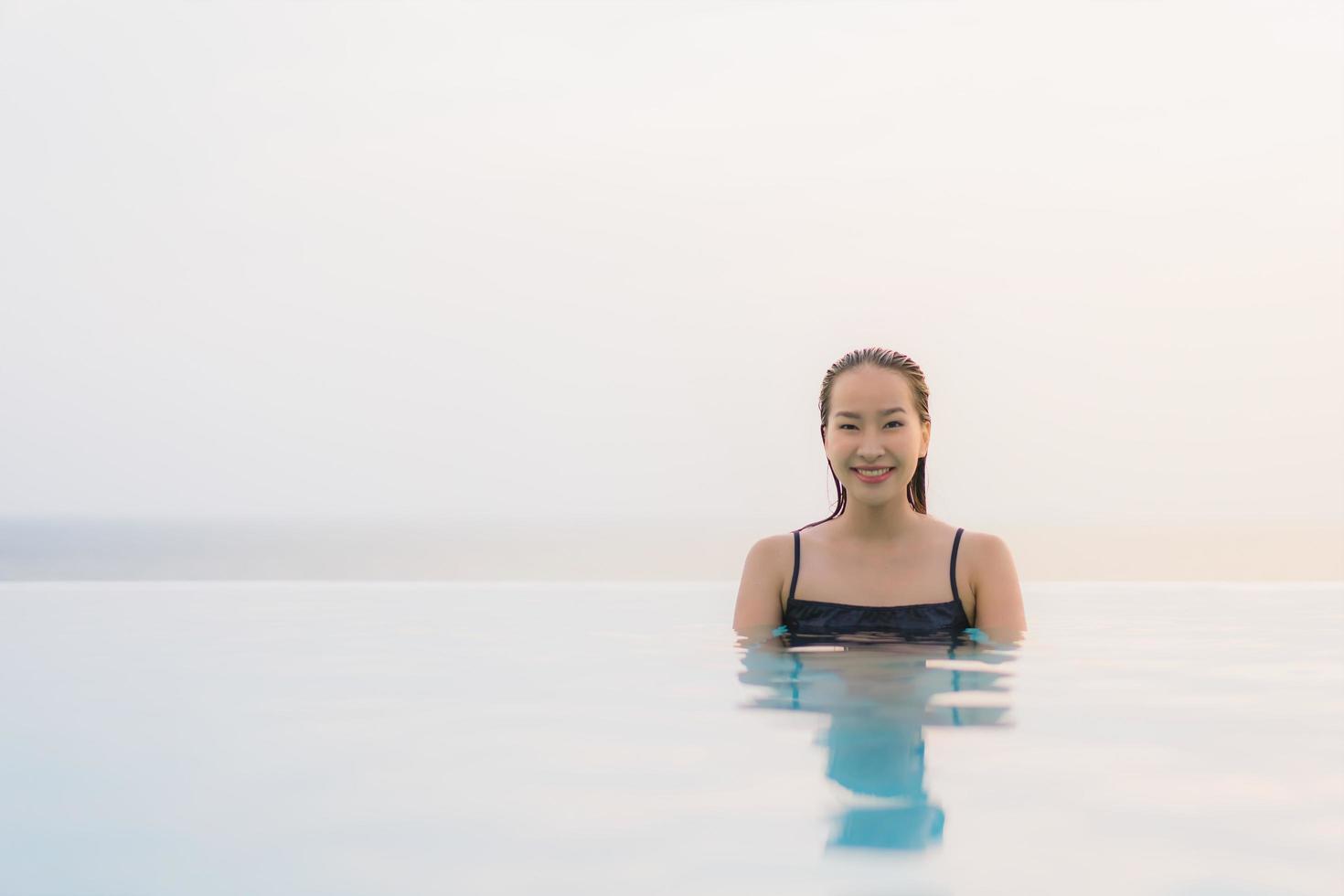 Porträt schöne junge asiatische Frau glückliches Lächeln entspannen sich am Swimmingpool im Hotelresort? foto