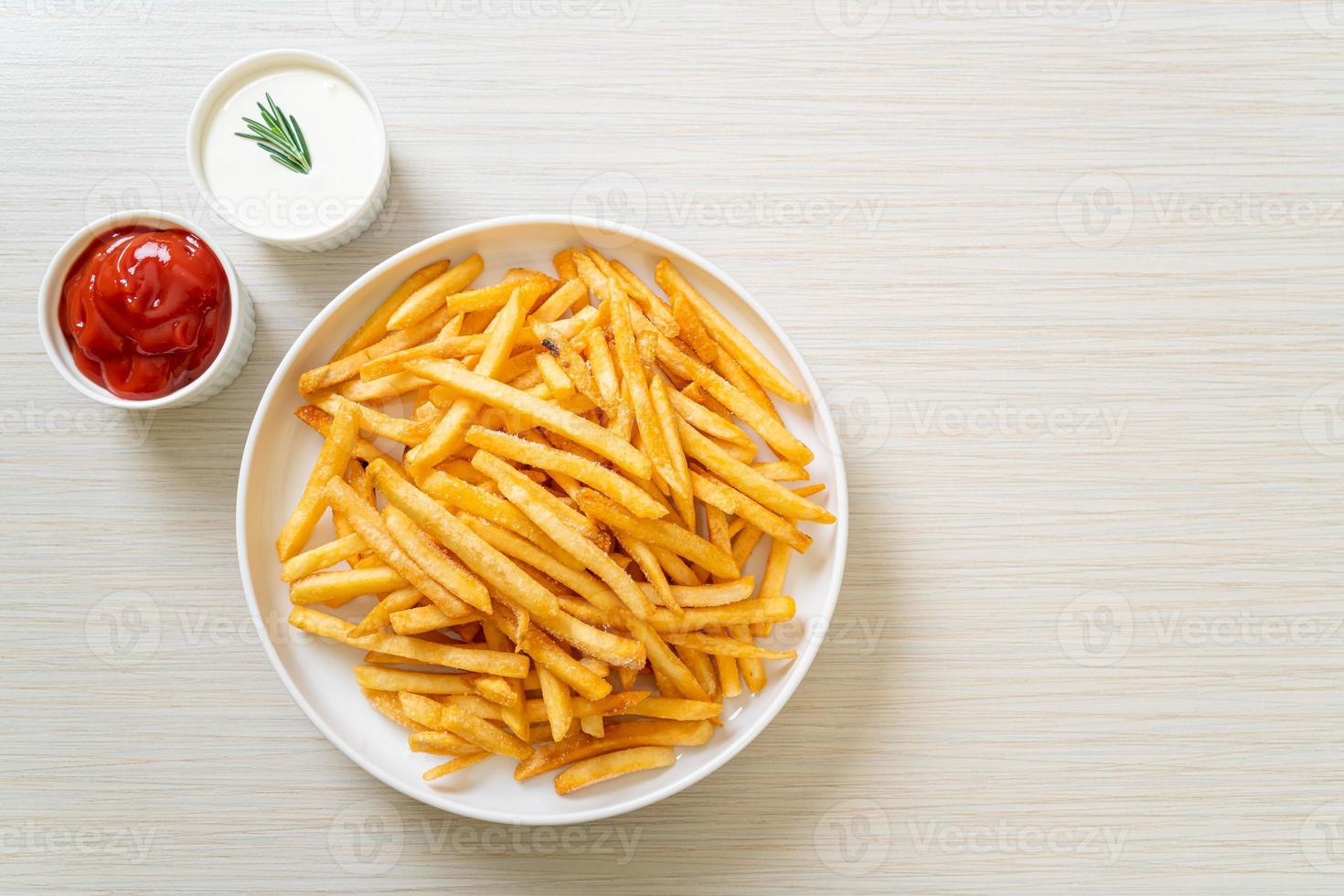 Pommes Frites mit Sauerrahm und Ketchup foto