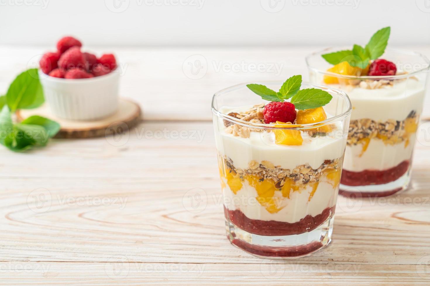 hausgemachte frische Mango und frische Himbeere mit Joghurt und Müsli - gesunder Ernährungsstil foto