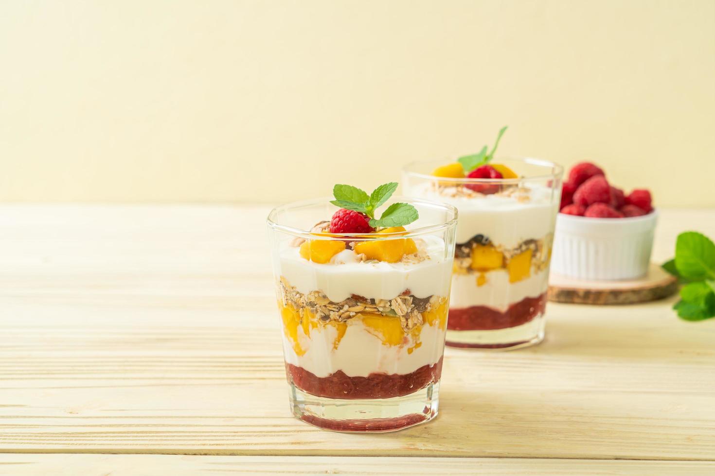 hausgemachte frische Mango und frische Himbeere mit Joghurt und Müsli - gesunder Ernährungsstil foto