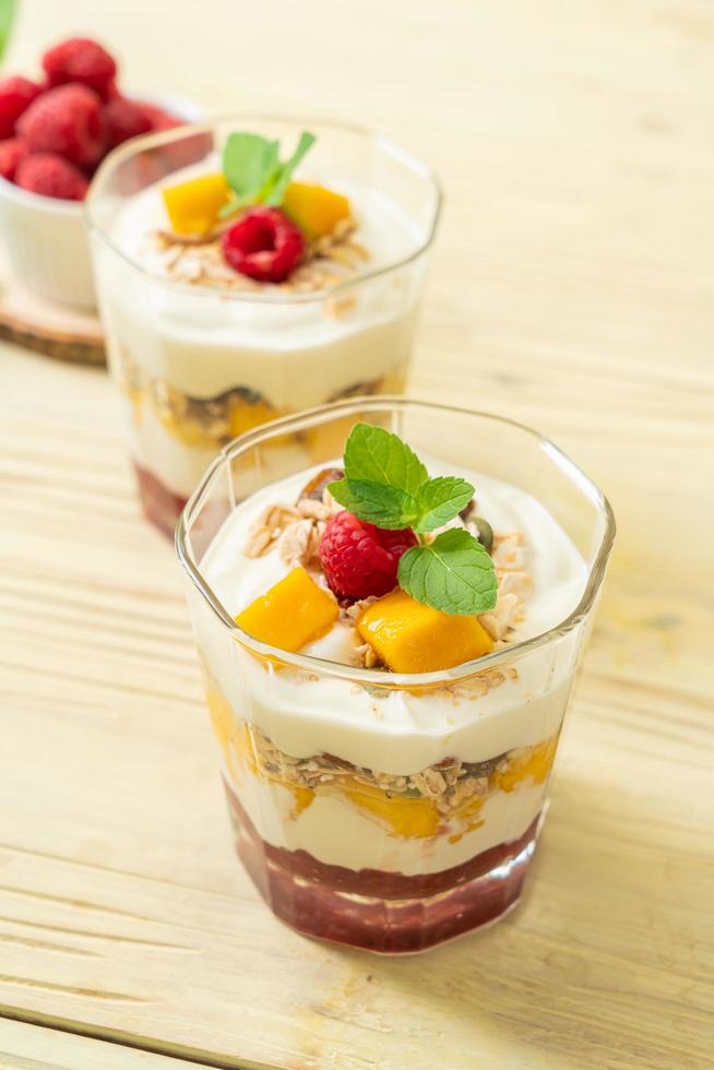 hausgemachte frische Mango und frische Himbeere mit Joghurt und Müsli - gesunder Ernährungsstil foto