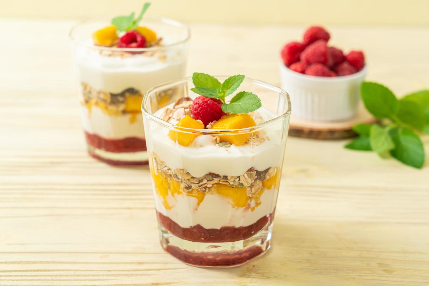 hausgemachte frische Mango und frische Himbeere mit Joghurt und Müsli - gesunder Ernährungsstil foto