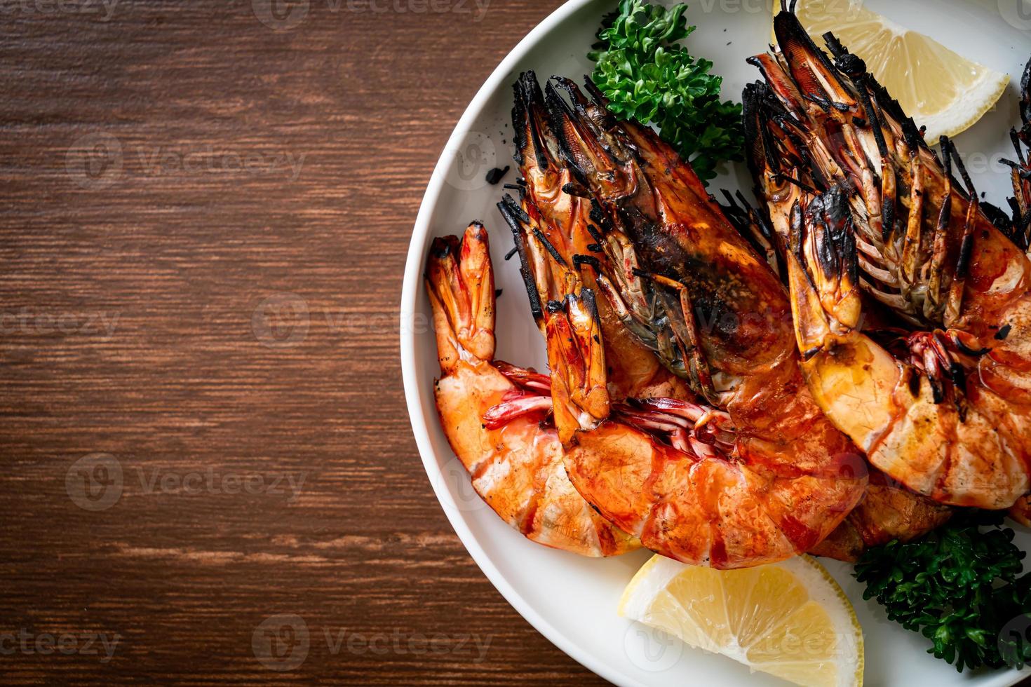 gegrillte Tigergarnelen oder Shrimps mit Zitrone auf einem Teller foto