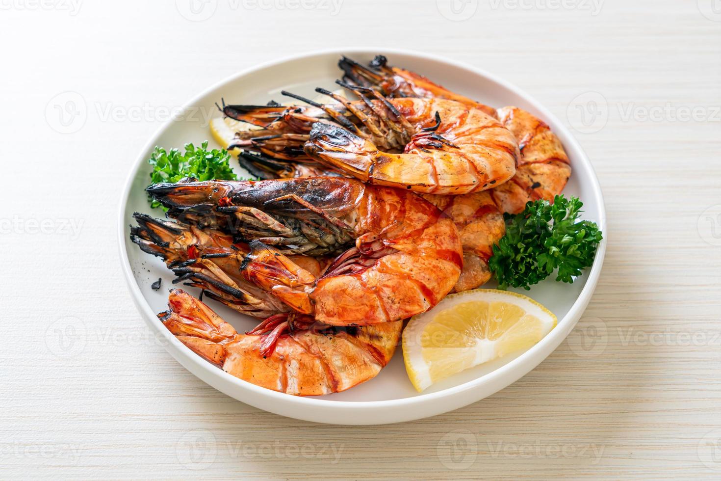 gegrillte Tigergarnelen oder Shrimps mit Zitrone auf einem Teller foto