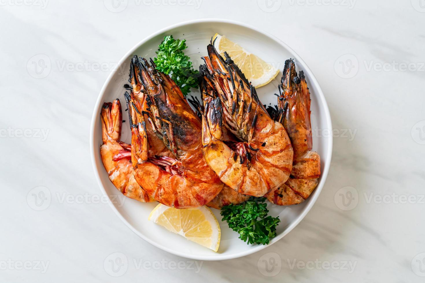 gegrillte Tigergarnelen oder Shrimps mit Zitrone auf einem Teller foto