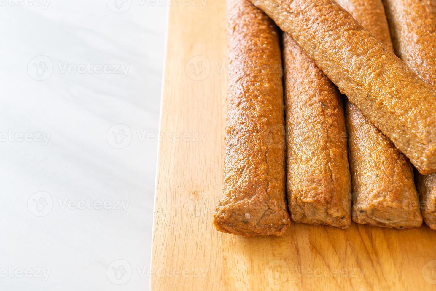 gebratener chinesischer Fischkuchen oder Fischbällchen-Linie auf Holzbrett foto