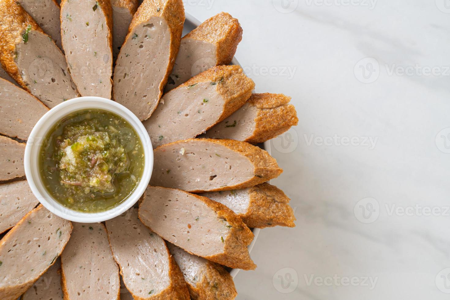 gebratener chinesischer Fischkuchen oder Fischbällchen in Scheiben geschnitten mit würziger Meeresfrüchte-Dip-Sauce foto