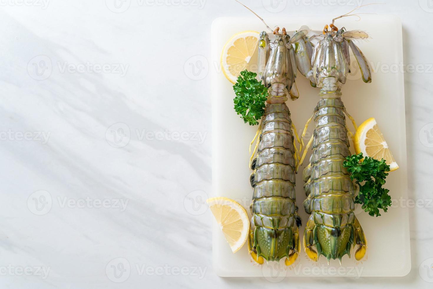 frische Fangschreckenkrebse mit Zitrone auf einem Brett foto