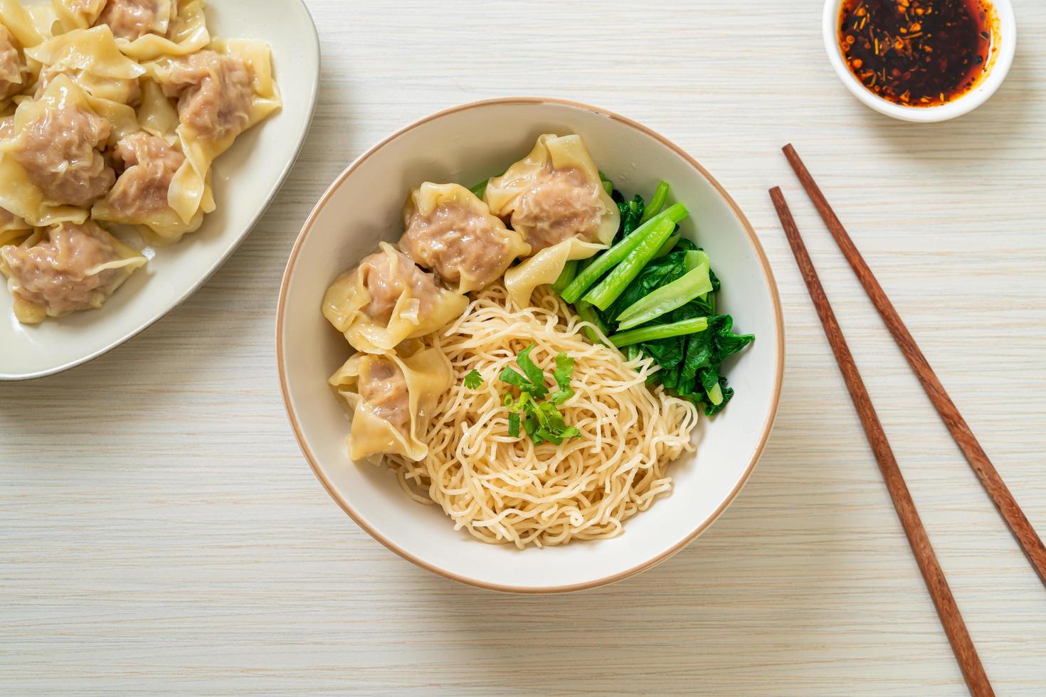 getrocknete Eiernudeln mit Schweinefleisch Wonton oder Schweineknödel ohne Suppe nach asiatischer Art foto