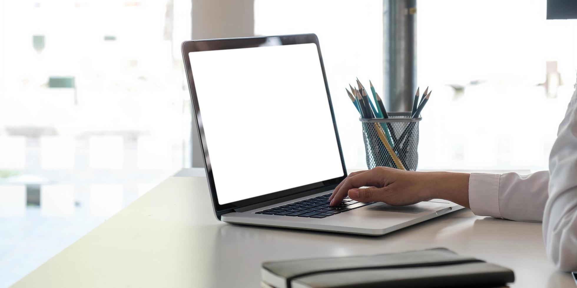 leerer Bildschirm Laptop-Computer und Plakatarbeitsplatzhintergrund im modernen Büro foto