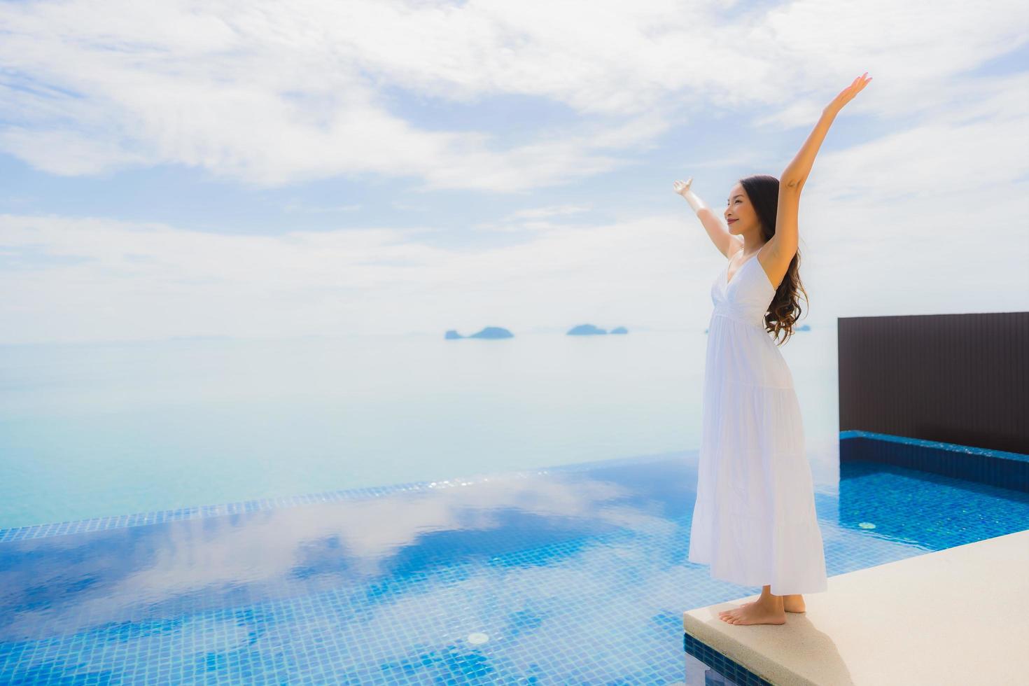 Porträt junge asiatische Frau entspannt Lächeln glücklich um Schwimmbad im Hotel und Resort foto