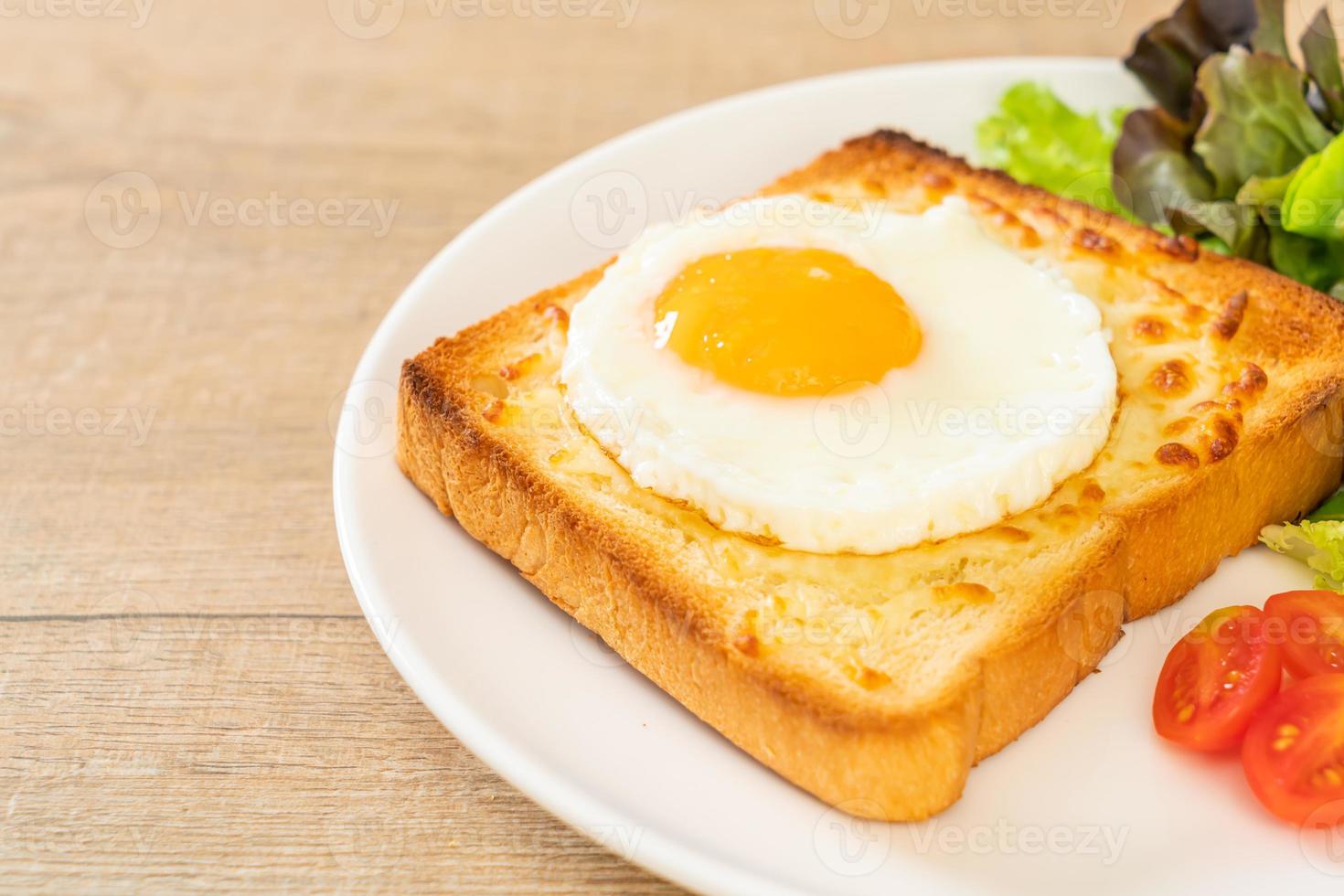 hausgemachtes Brot geröstet mit Käse und Spiegelei obenauf mit Gemüsesalat zum Frühstück foto