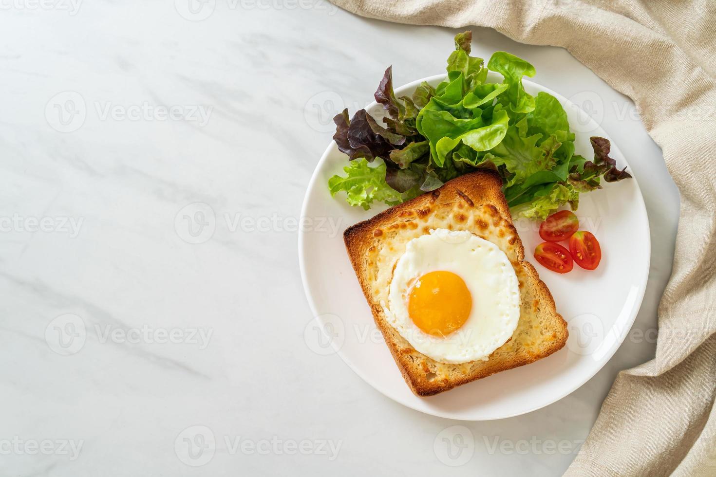 hausgemachtes Brot geröstet mit Käse und Spiegelei obenauf mit Gemüsesalat zum Frühstück foto