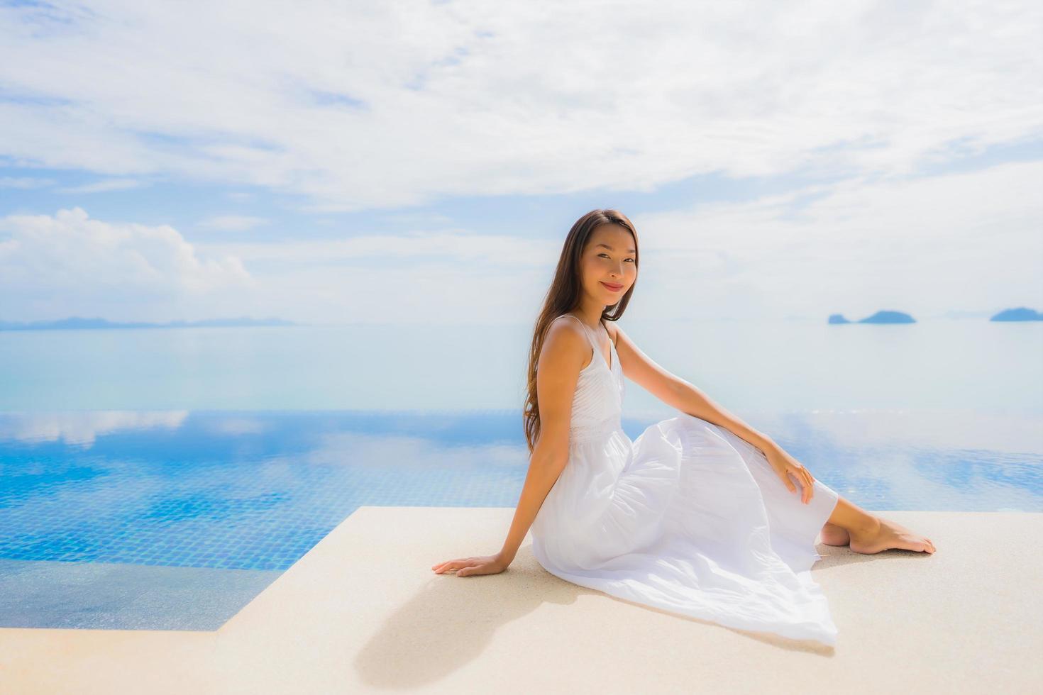 Porträt junge asiatische Frau entspannt Lächeln glücklich um Schwimmbad im Hotel und Resort foto