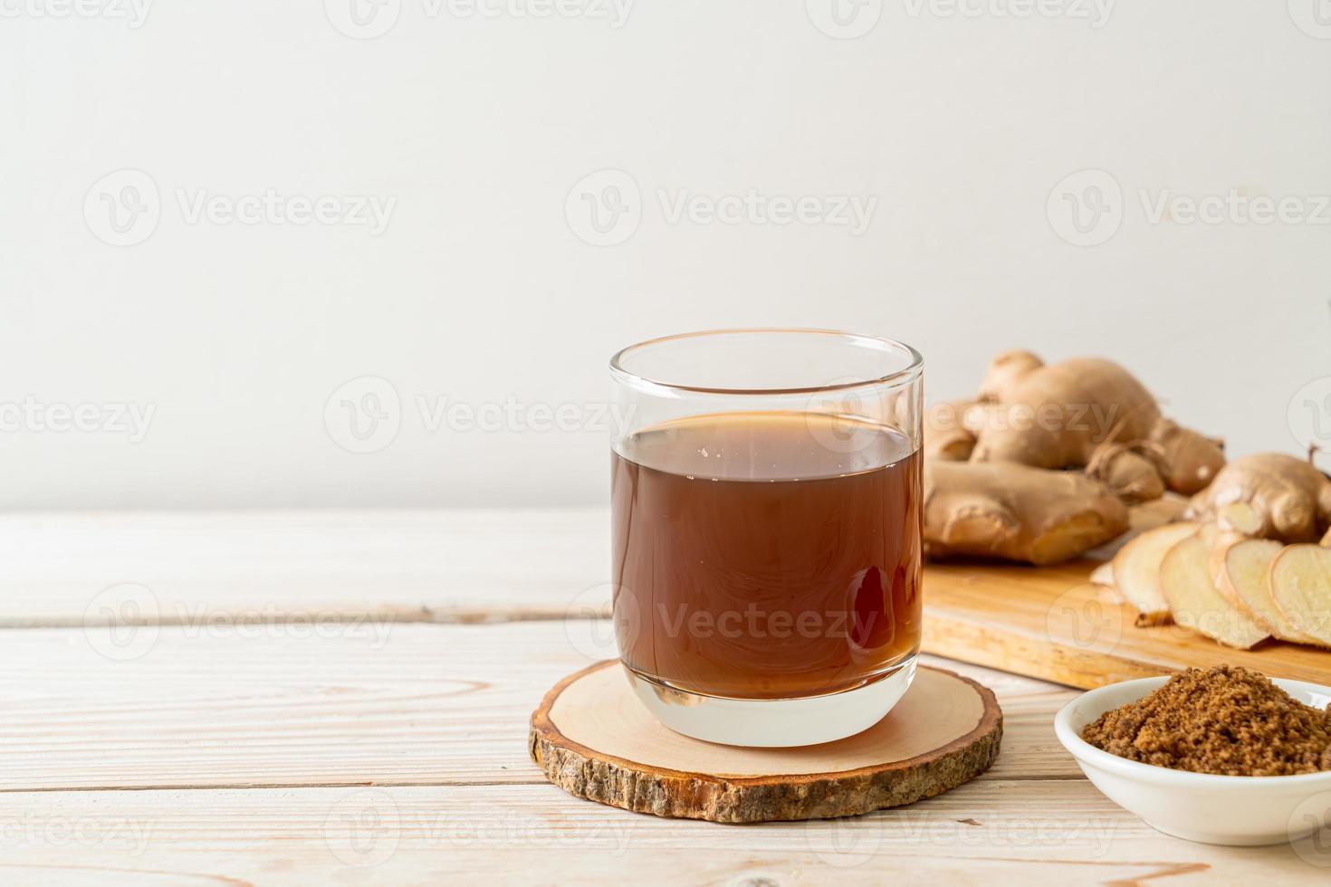 heißes und süßes Ingwersaftglas mit Ingwerwurzeln - gesunde Getränkeart foto