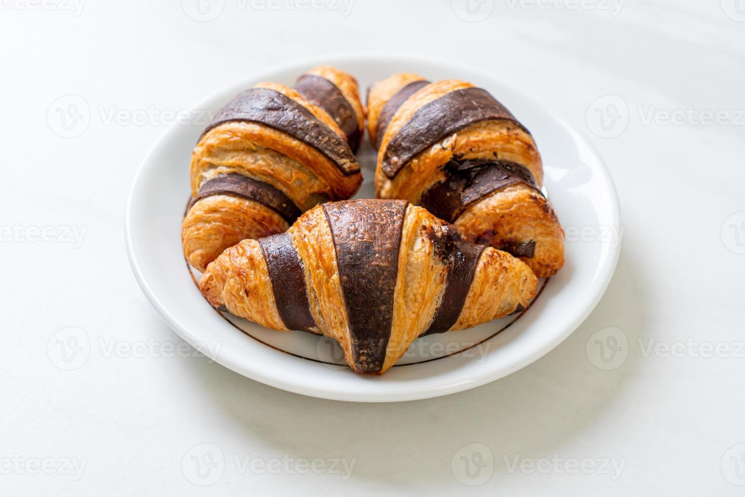 frisches Croissant mit Schokolade auf Teller foto