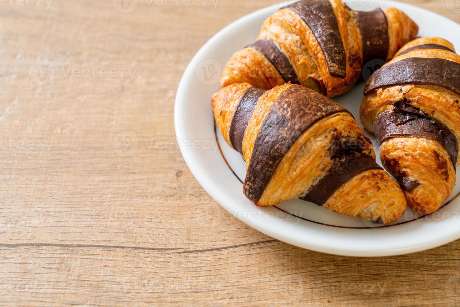 frisches Croissant mit Schokolade auf Teller foto