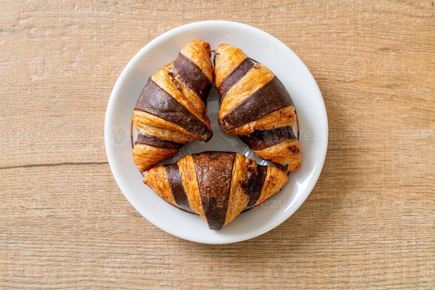 frisches Croissant mit Schokolade auf Teller foto