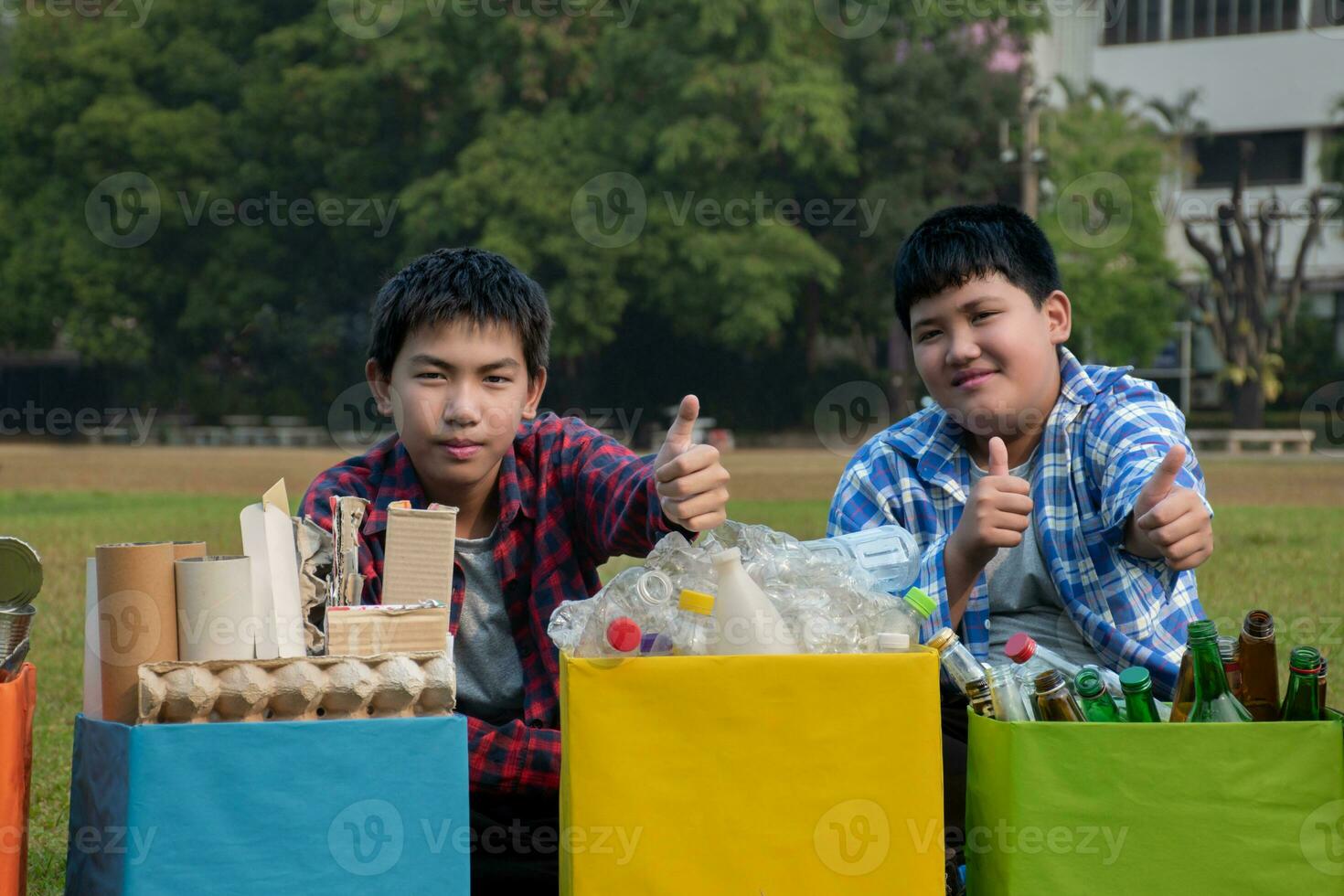 asiatisch Junge im Plaid Hemd Sitzung auf Spielplatz von Schule mit verschiedene Kisten von getrennt Garbabes oder Müll innen, Konzept zum Öko freunde und global Erwärmen Kampagne, Sanft und selektiv Fokus. foto