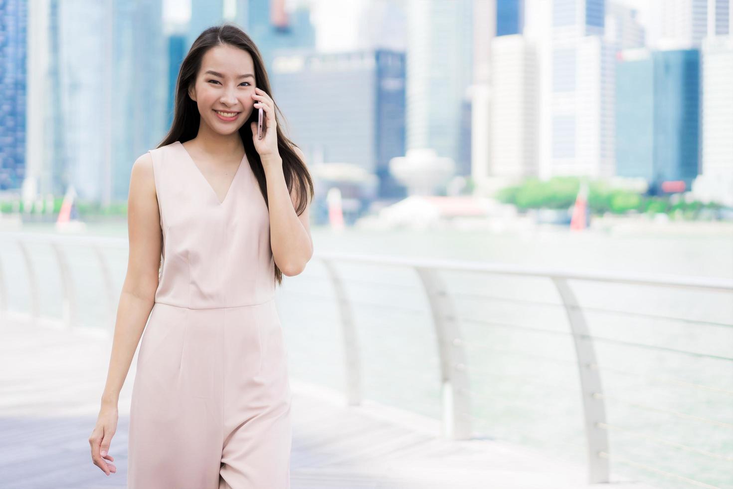 asiatische Frau, die Smartphone oder Handy zum Sprechen oder Text verwendet foto