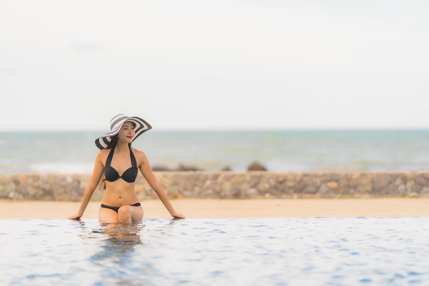 Porträt schöne junge asiatische Frau tragen Bikini um Schwimmbad im Hotelresort fast Meer Ozean Strand? foto