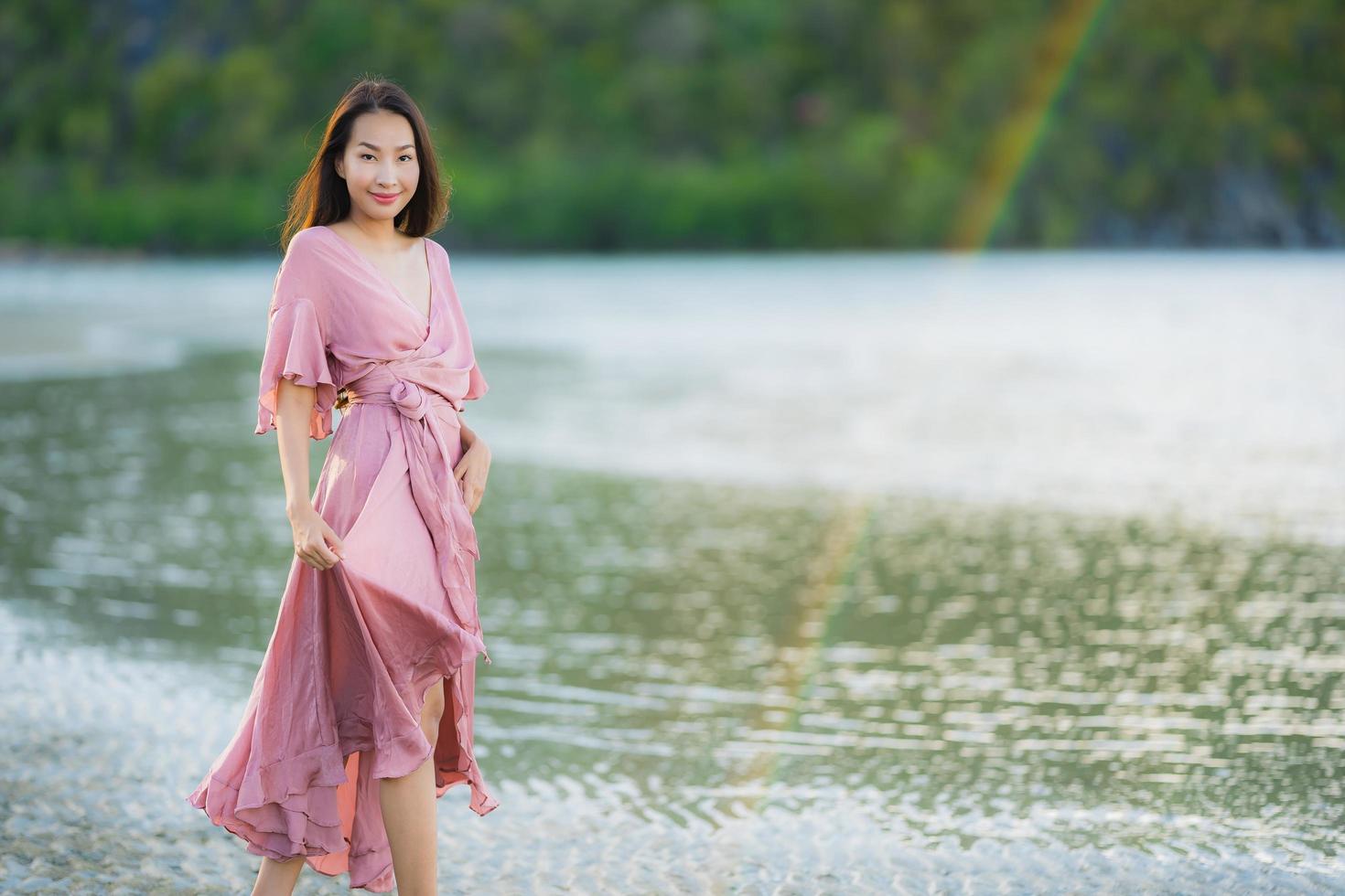 Porträt junge schöne asiatische Frau Spaziergang Lächeln und glücklich am Strand Meer und Ozean foto