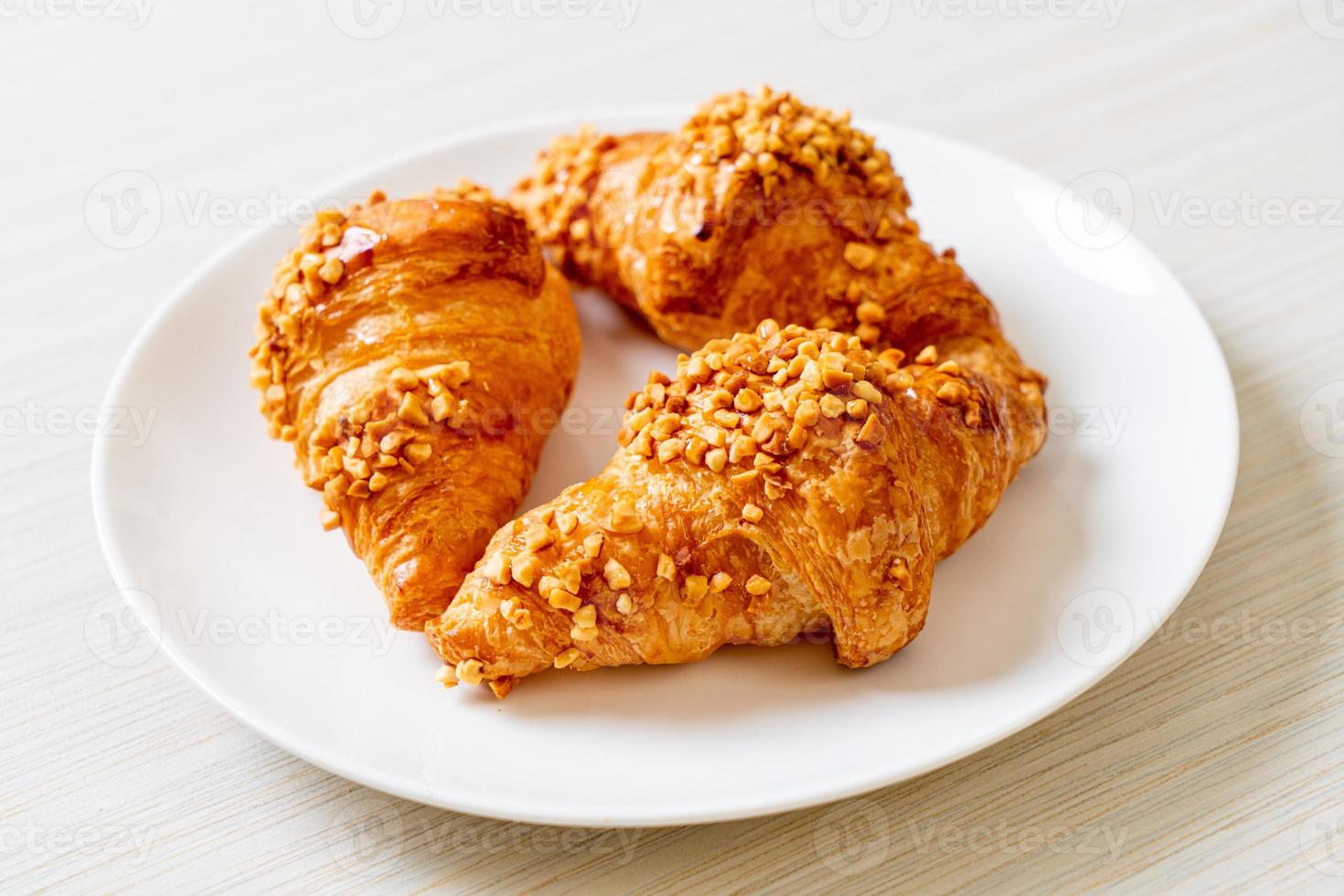 frisches Croissant mit Erdnuss auf Teller foto