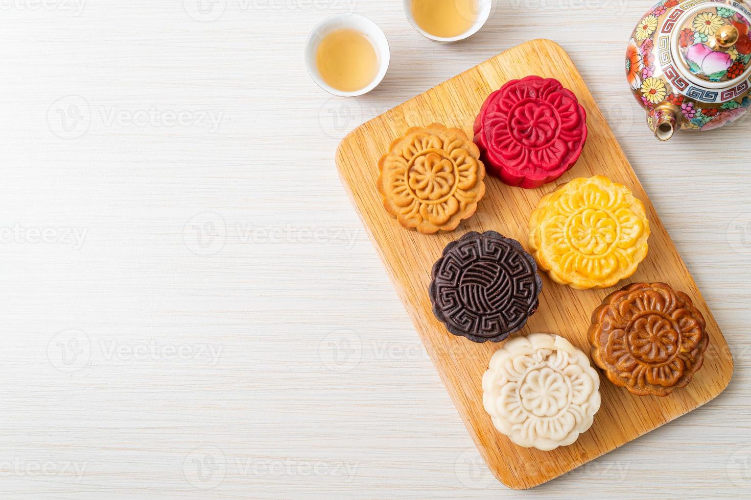 bunter chinesischer Mondkuchen mit gemischtem Geschmack auf Holzteller foto