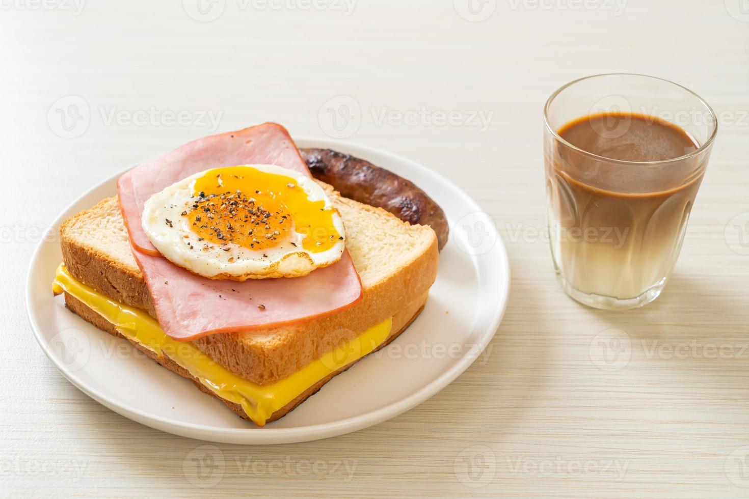 hausgemachtes Brot, gerösteter Käse, belegter Schinken und Spiegelei mit Schweinswurst zum Frühstück foto