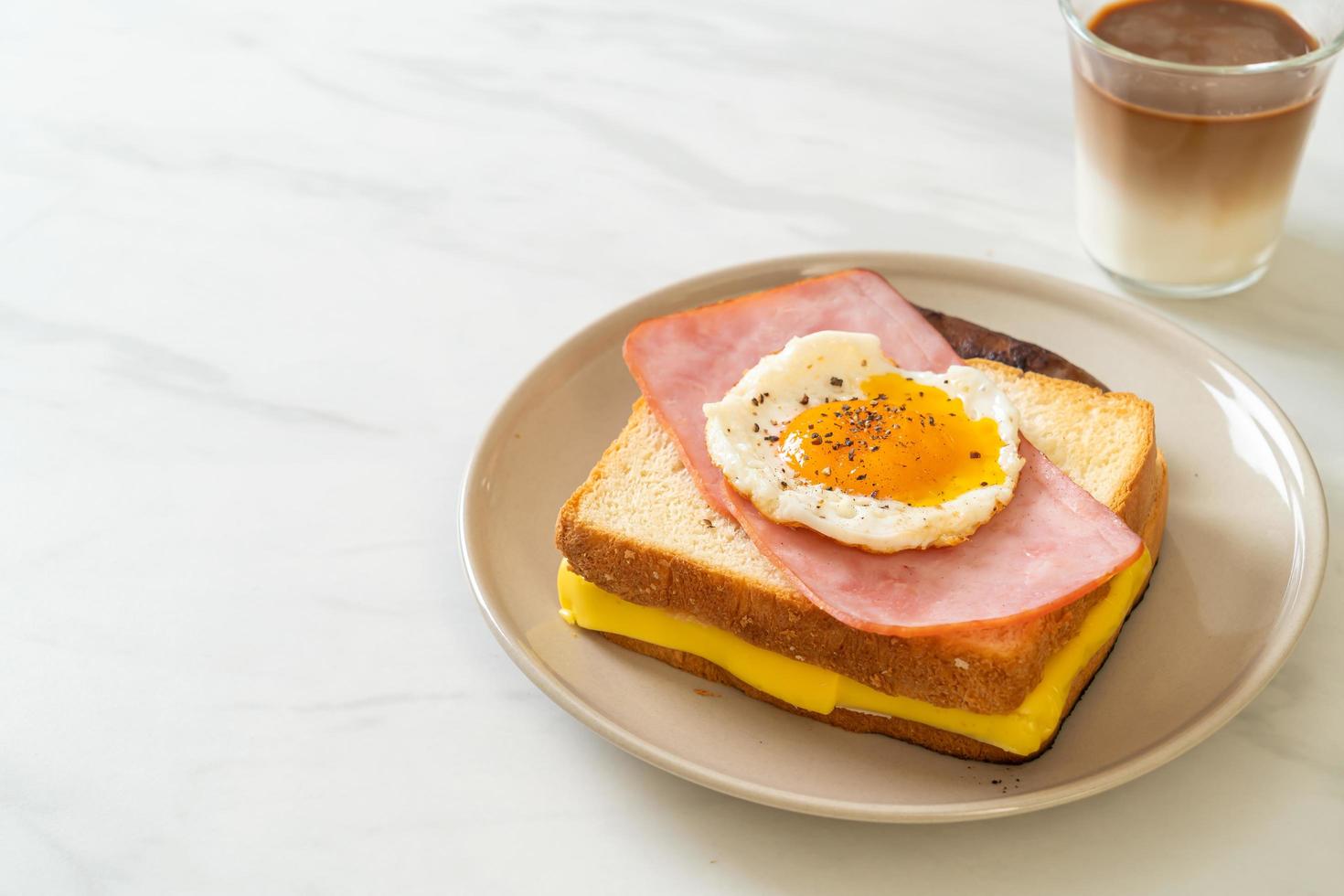 hausgemachtes Brot, gerösteter Käse, belegter Schinken und Spiegelei mit Schweinswurst zum Frühstück foto