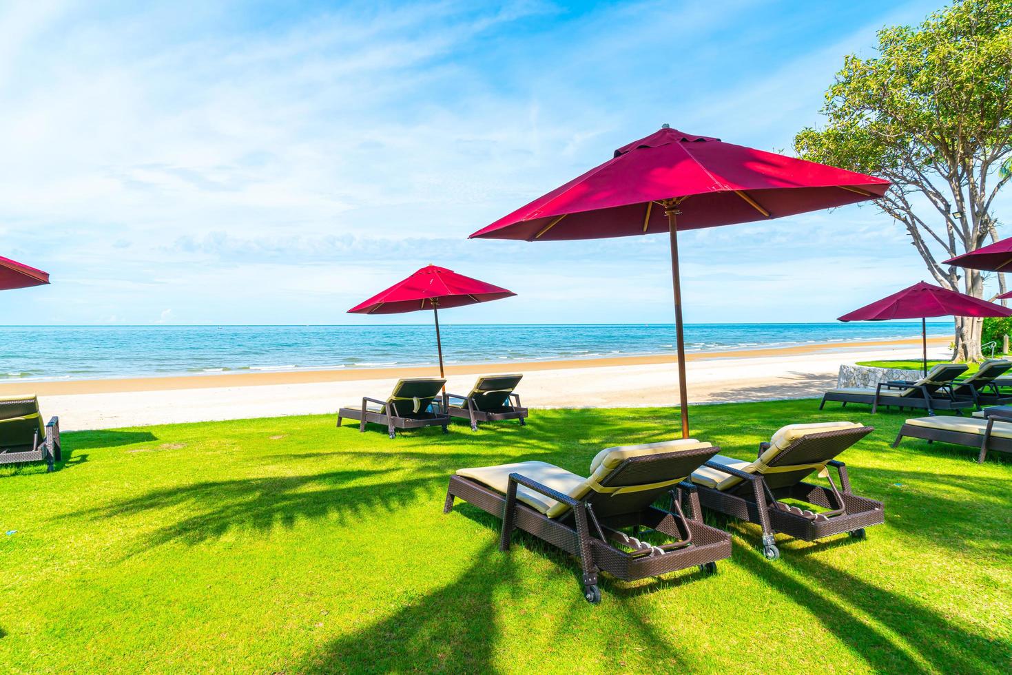 Strandkörbe und Sonnenschirme mit Ozean Meer Strand Hintergrund foto