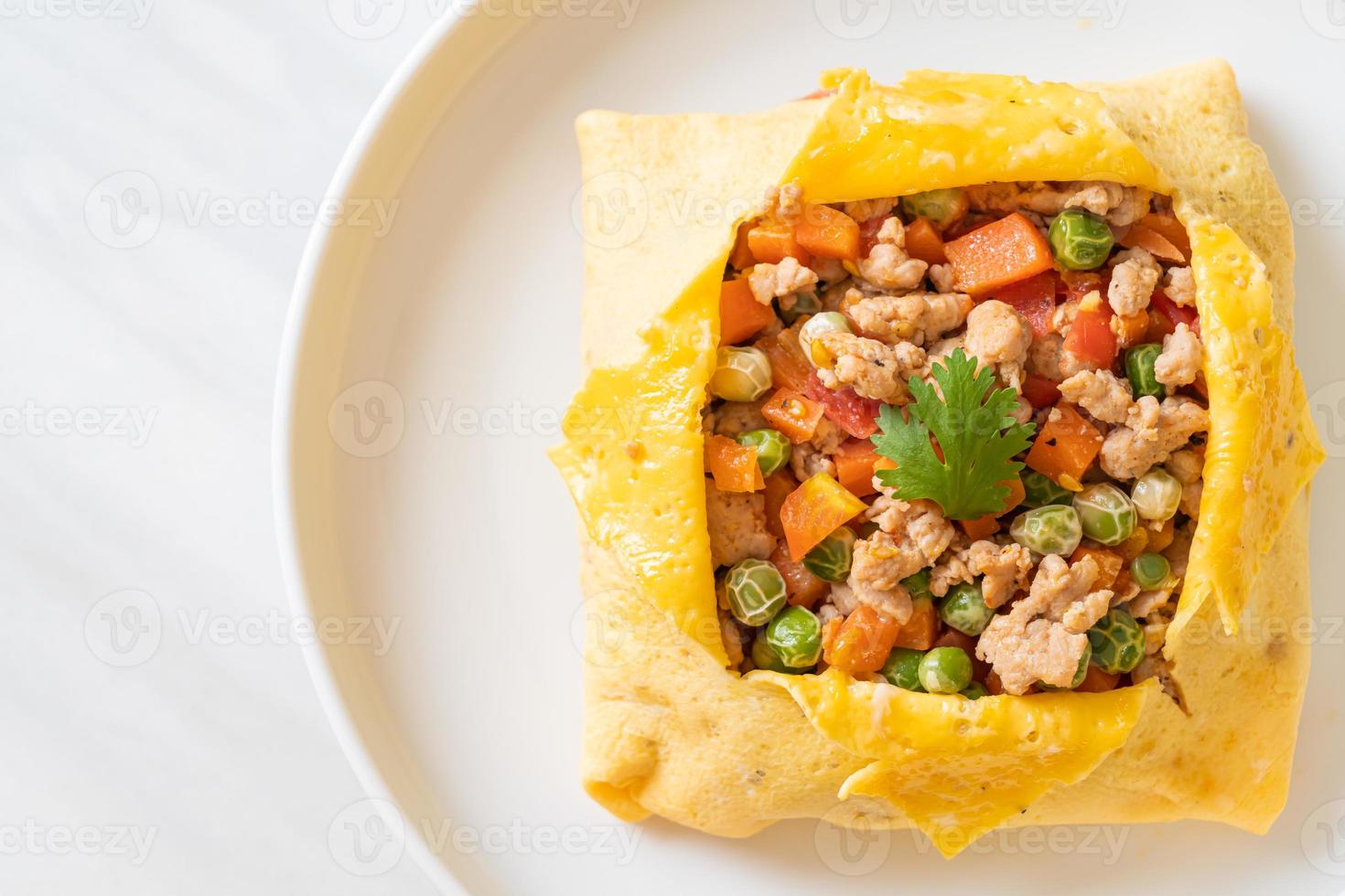 Eierwickel oder gefülltes Ei mit Hackfleisch, Karotten, Tomaten und grünen Erbsen foto