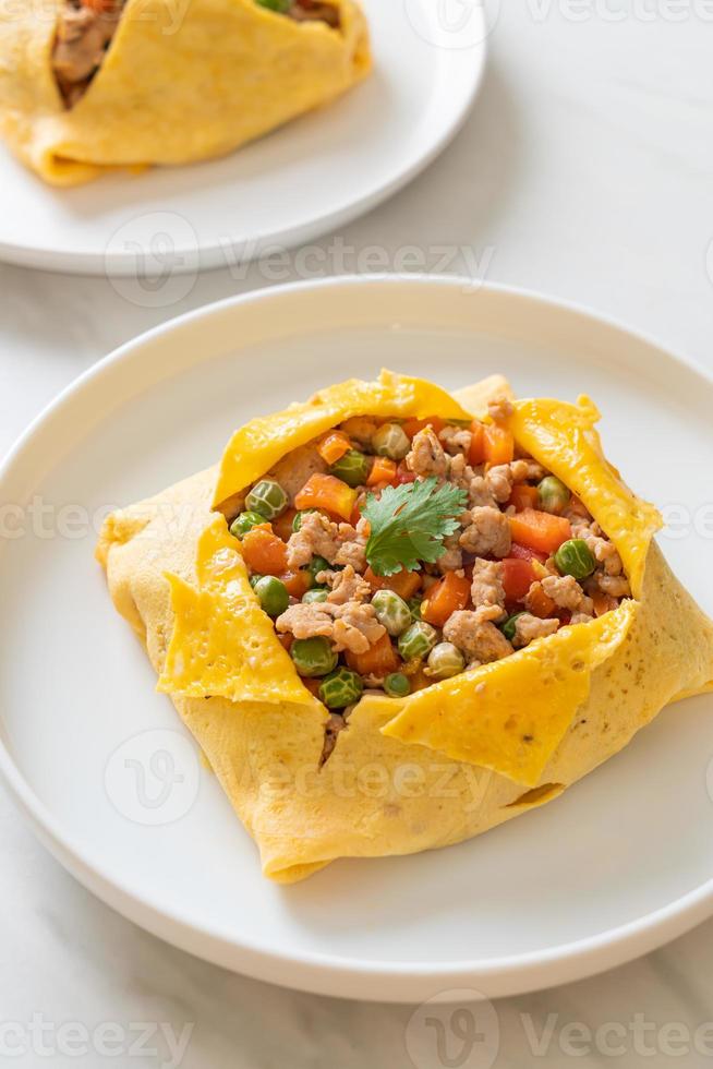 Eierwickel oder gefülltes Ei mit Hackfleisch, Karotten, Tomaten und grünen Erbsen foto