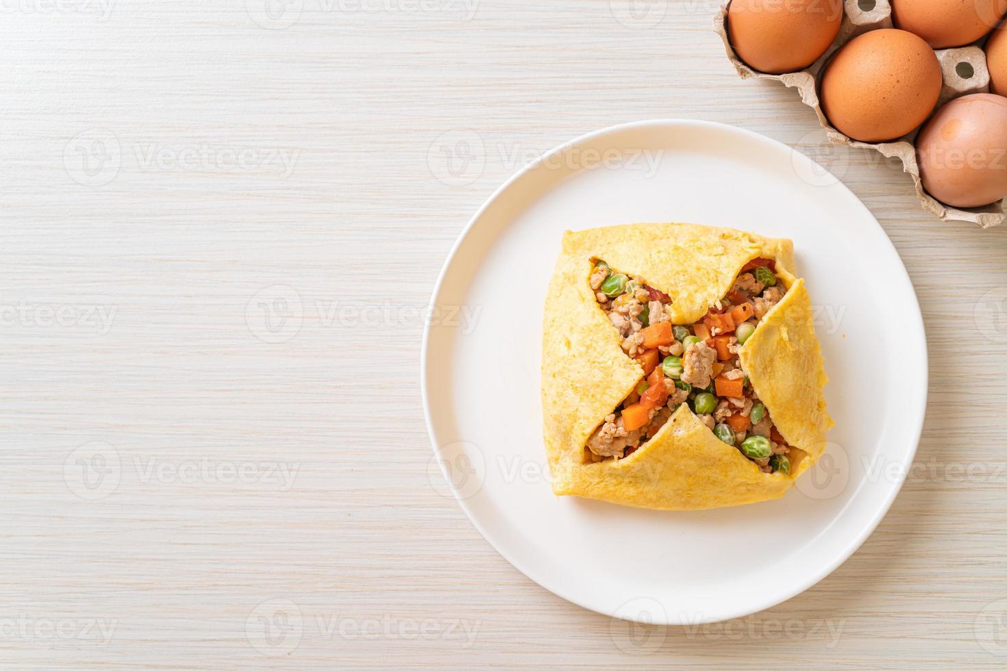 Eierwickel oder gefülltes Ei mit Hackfleisch, Karotten, Tomaten und grünen Erbsen foto