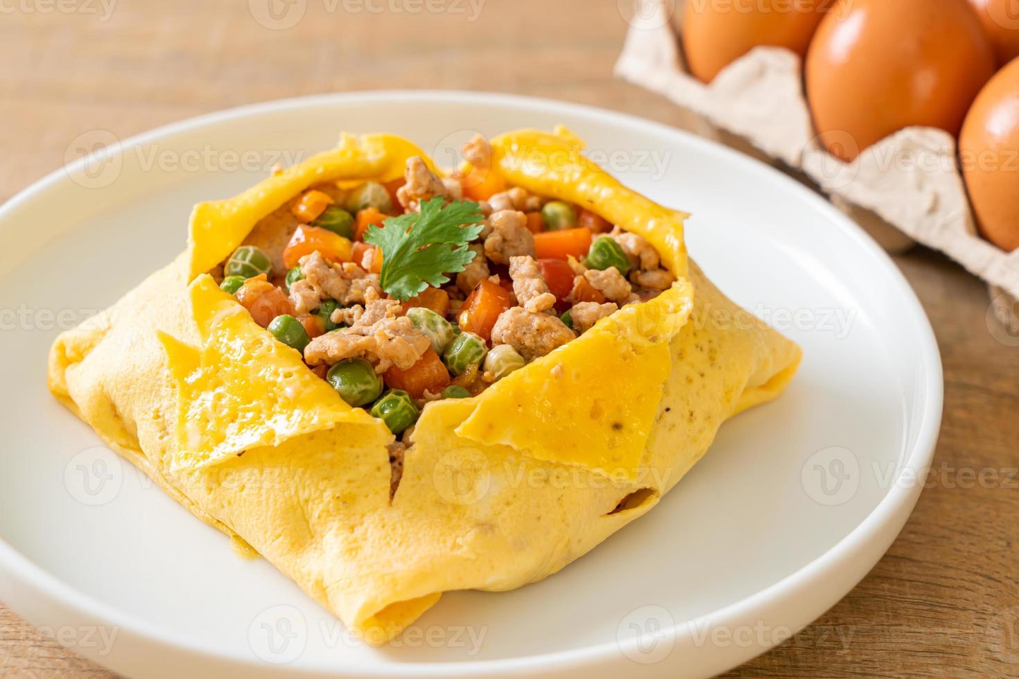 Eierwickel oder gefülltes Ei mit Hackfleisch, Karotten, Tomaten und grünen Erbsen foto