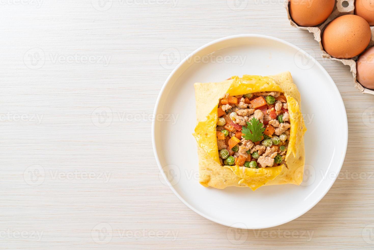 Eierwickel oder gefülltes Ei mit Hackfleisch, Karotten, Tomaten und grünen Erbsen foto