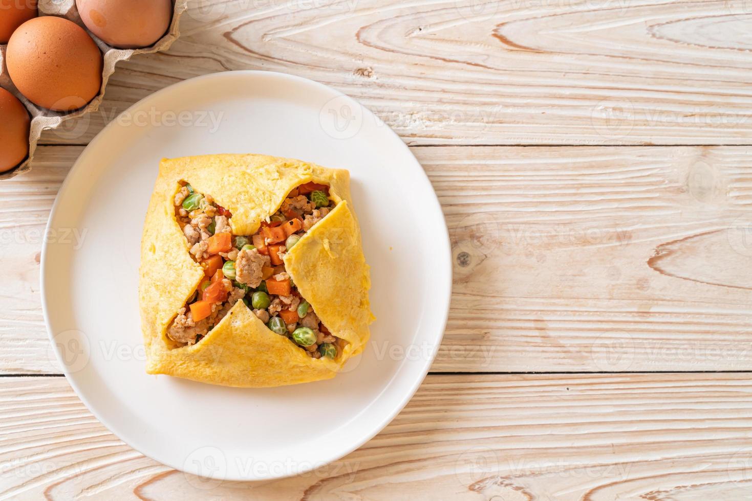 Eierwickel oder gefülltes Ei mit Hackfleisch, Karotten, Tomaten und grünen Erbsen foto