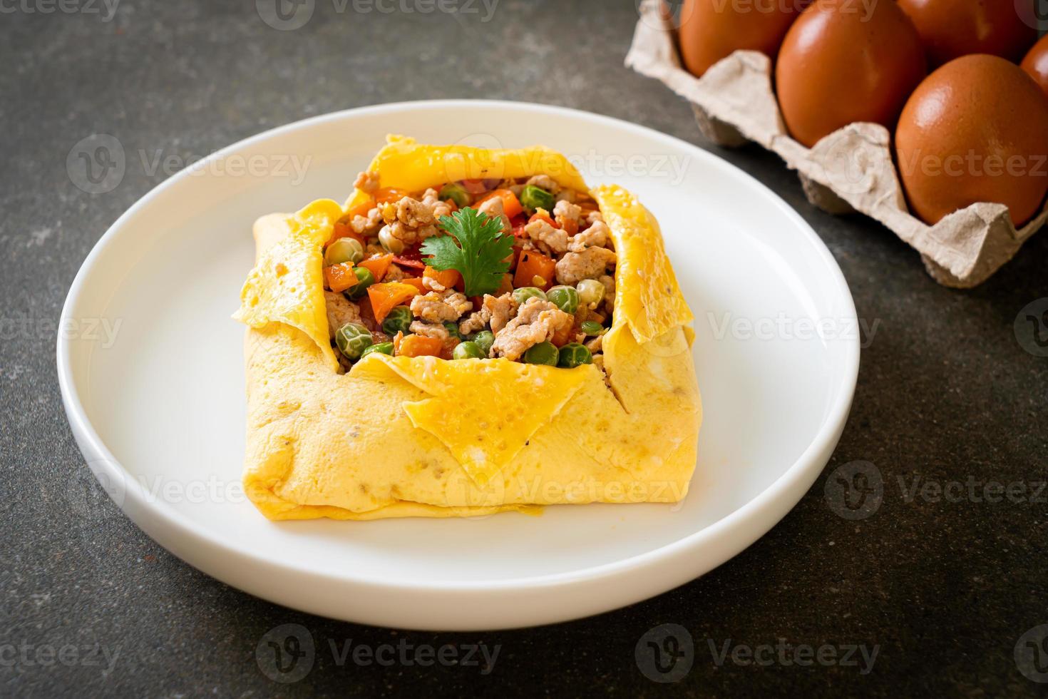 Eierwickel oder gefülltes Ei mit Hackfleisch, Karotten, Tomaten und grünen Erbsen foto